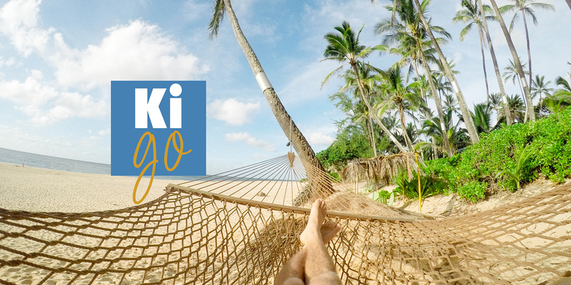 Füsse in einer Hängematte am Palmenstrand.