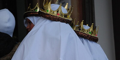 3 goldene verzierte Kronen auf weißen Kopftüchern