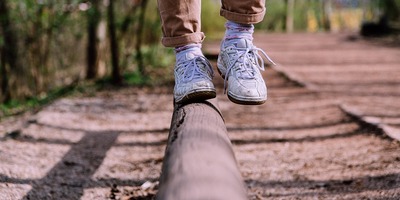 Füße, die auf einem Balken balancieren